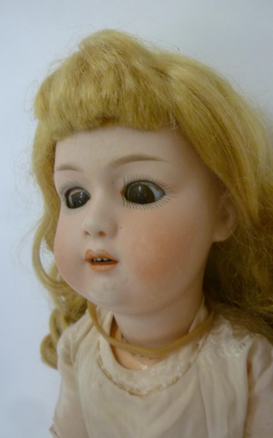 A Gebruder Heubach bisque head character doll with brown glass sleeping eyes Image