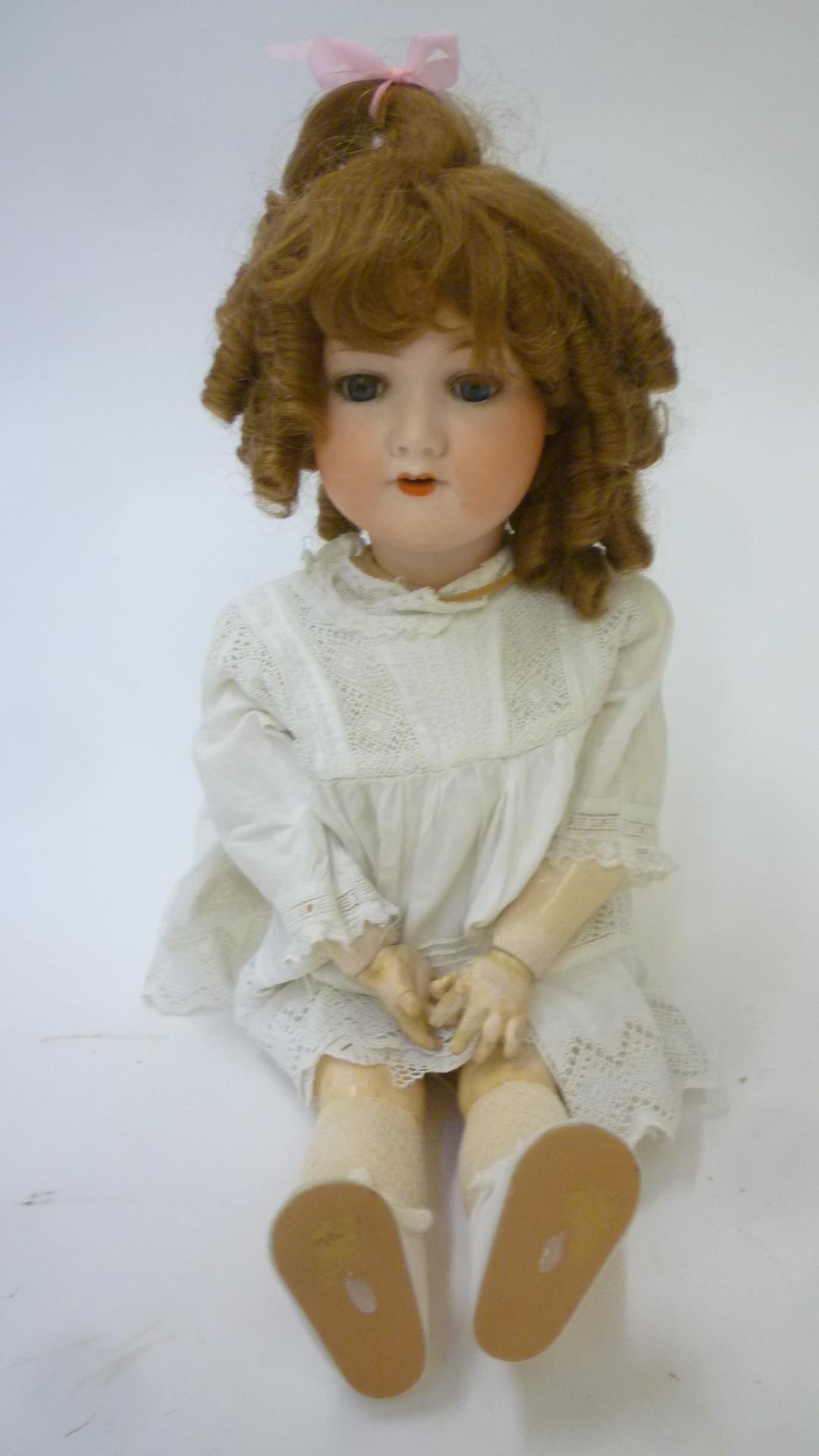 An Armand Marseille bisque head doll with blue glass sleeping eyes Image