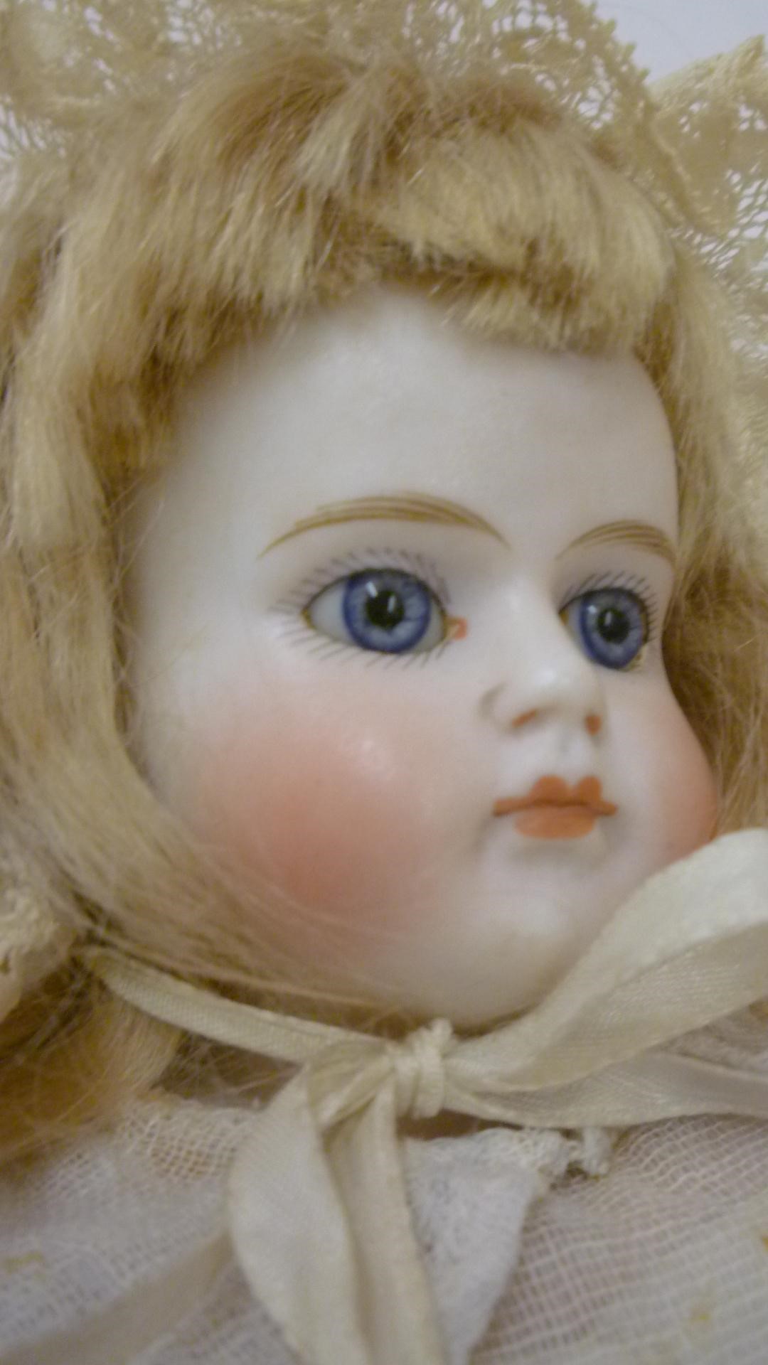 A Belton bisque shoulder head doll with fixed blue glass eyes Image