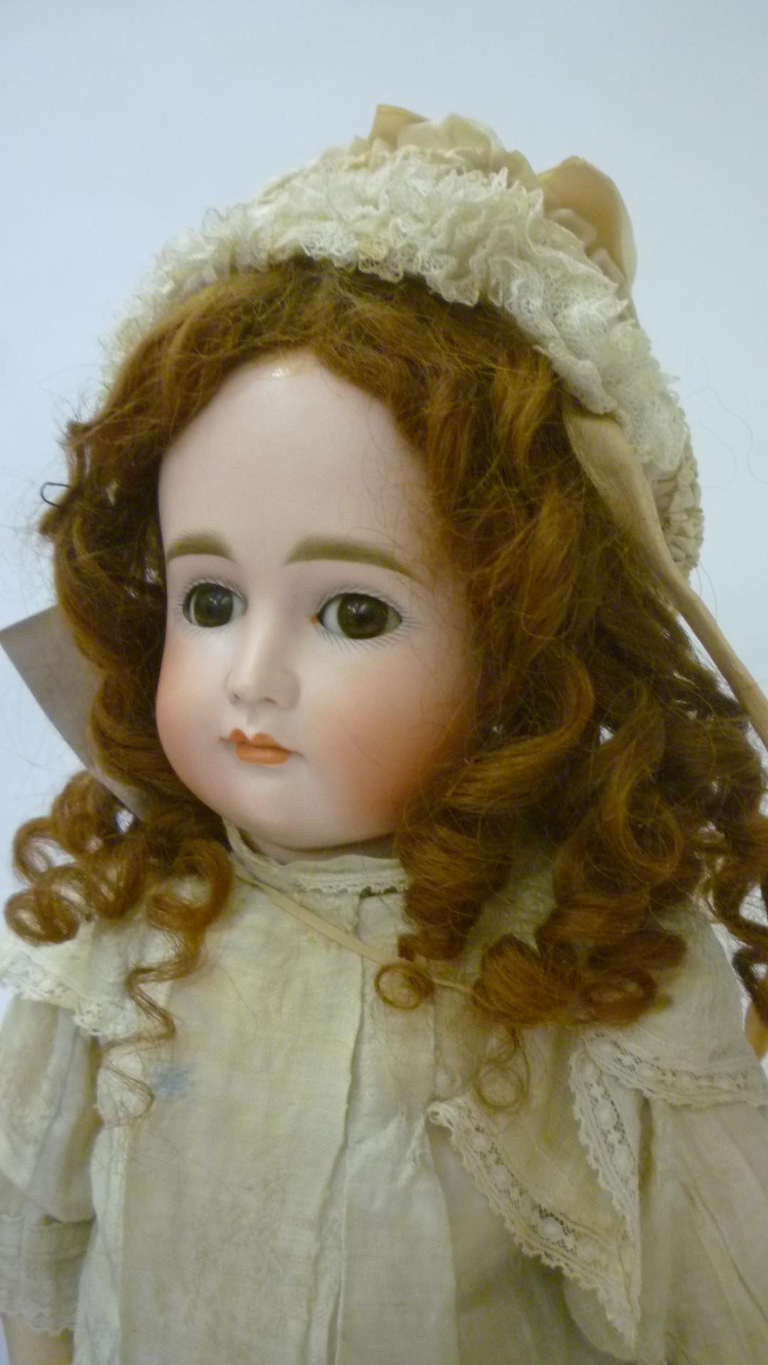 A Kestner bisque head doll with brown glass sleeping eyes Image