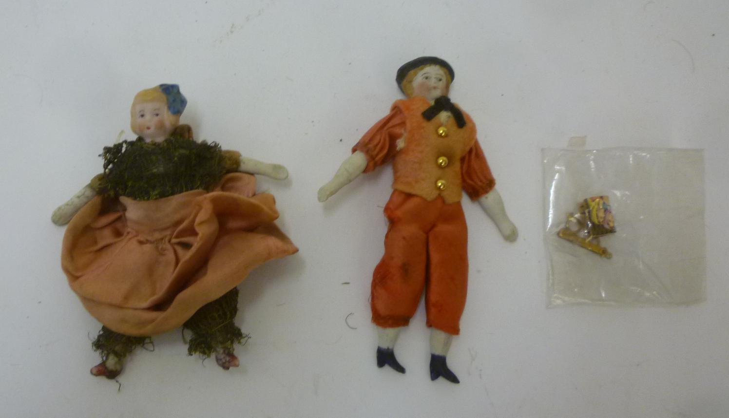 A pair of bisque male and female dolls house dolls with painted faces and moulded hat/hair Image