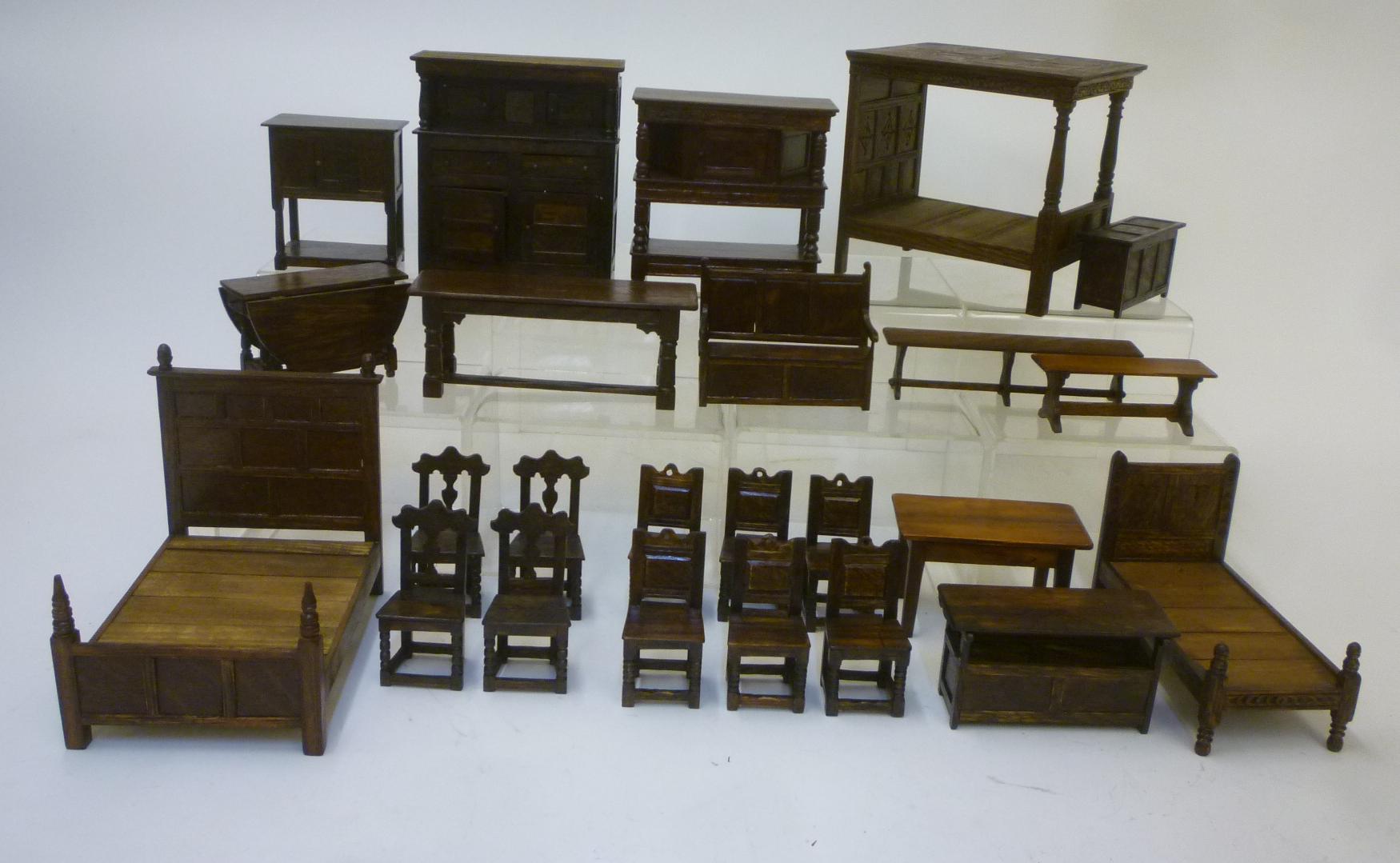 A collection of twenty five items of handmade oak doll's house furniture including a four poster bed Image