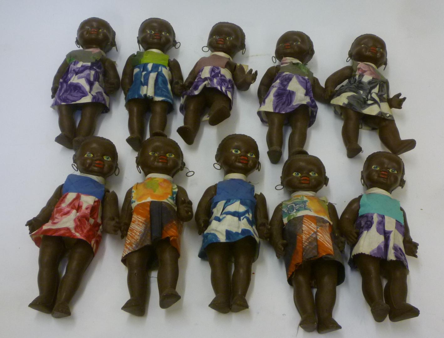 A set of ten black plastic dolls Image
