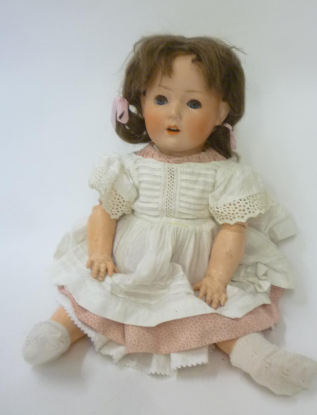A Schoenau & Hoffmeister bisque head doll with blue glass sleeping eyes Image