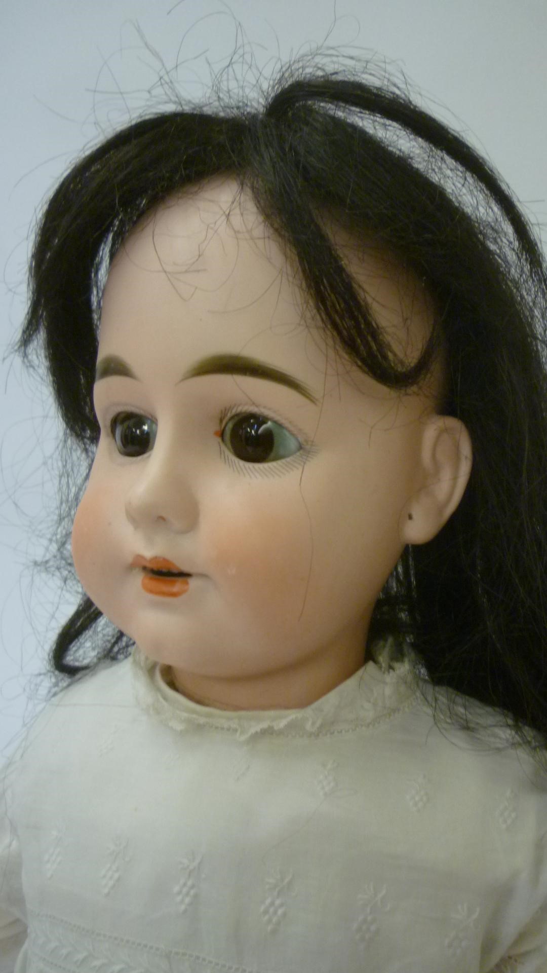 A Max Rader bisque head doll with brown glass sleeping eyes Image