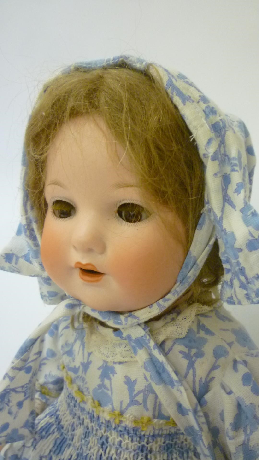 An Armand Marseille bisque head character doll with brown glass sleeping eyes Image