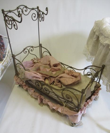 Two dolls beds and a raised crib Image