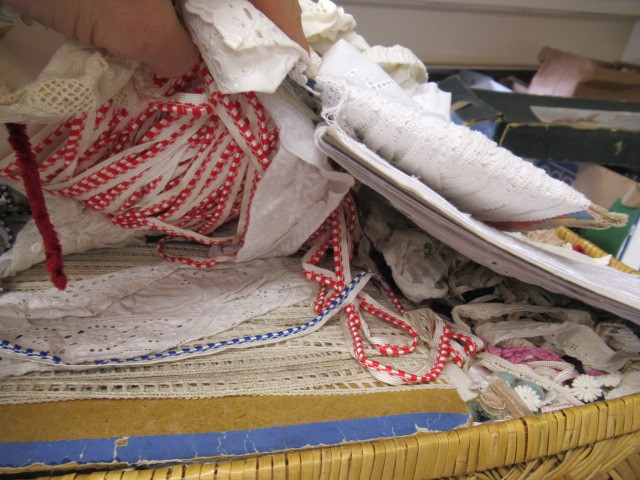 Three boxes and a basket of dolls cloths Image