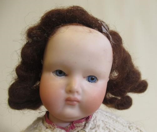 Two bisque socket head dolls comprising a 7 1/2" doll with blue glass sleeping eyes Image