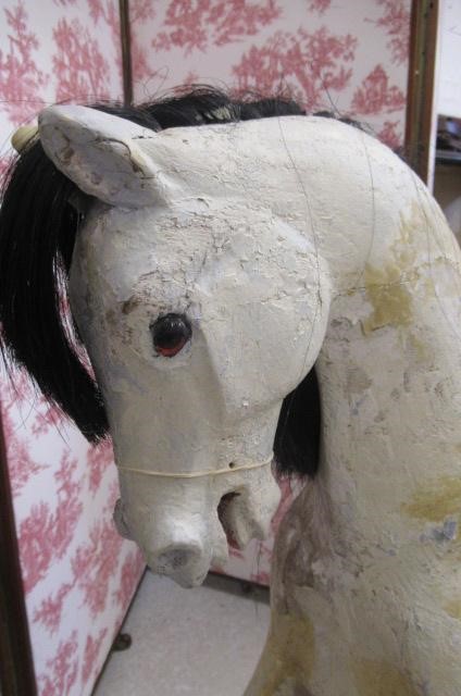 A carved wood rocking horse in white Image