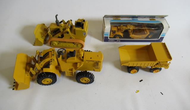 Four Caterpillar construction vehicles comprising Tractor Scraper Image