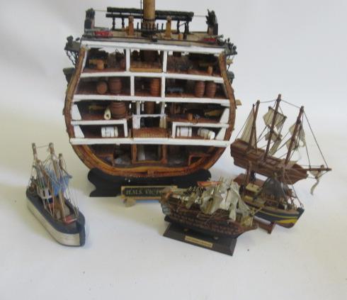 Section model of H.M.S. Victory and four small wooden ship models Image