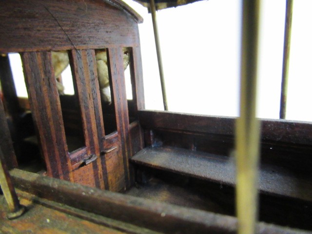 A modern wooden model of a steam launch and four lead figures with flag Image