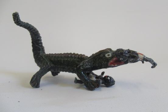 An unidentified crocodile with two children solid cast figures Image