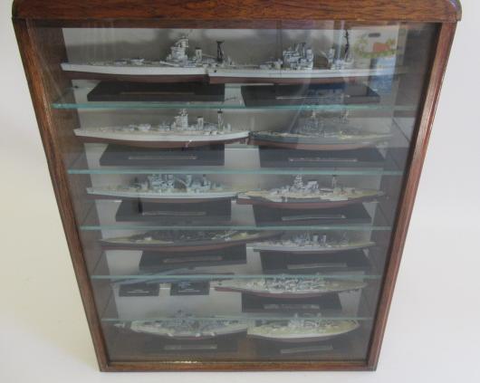 Twelve small scale 1:700 Battleship models in display cabinet Image