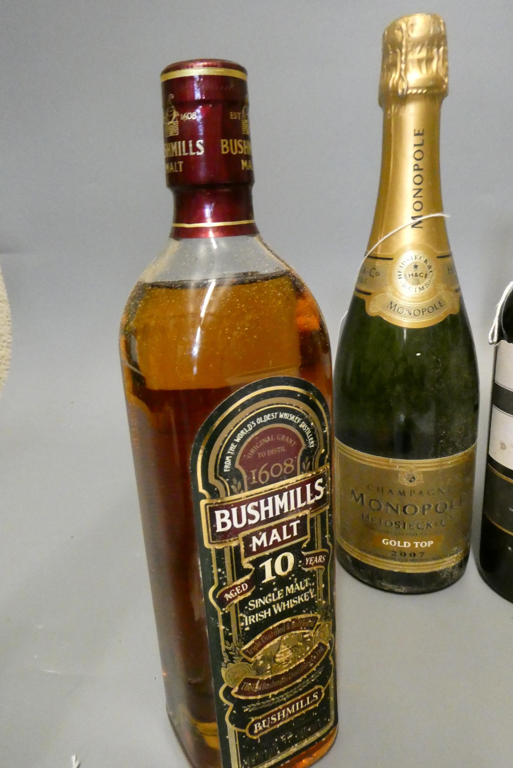 Three mixed bottles, comprising a tubed Bushmill's 10yr old Irish whiskey, a Monopole Gold Top 2007 Image