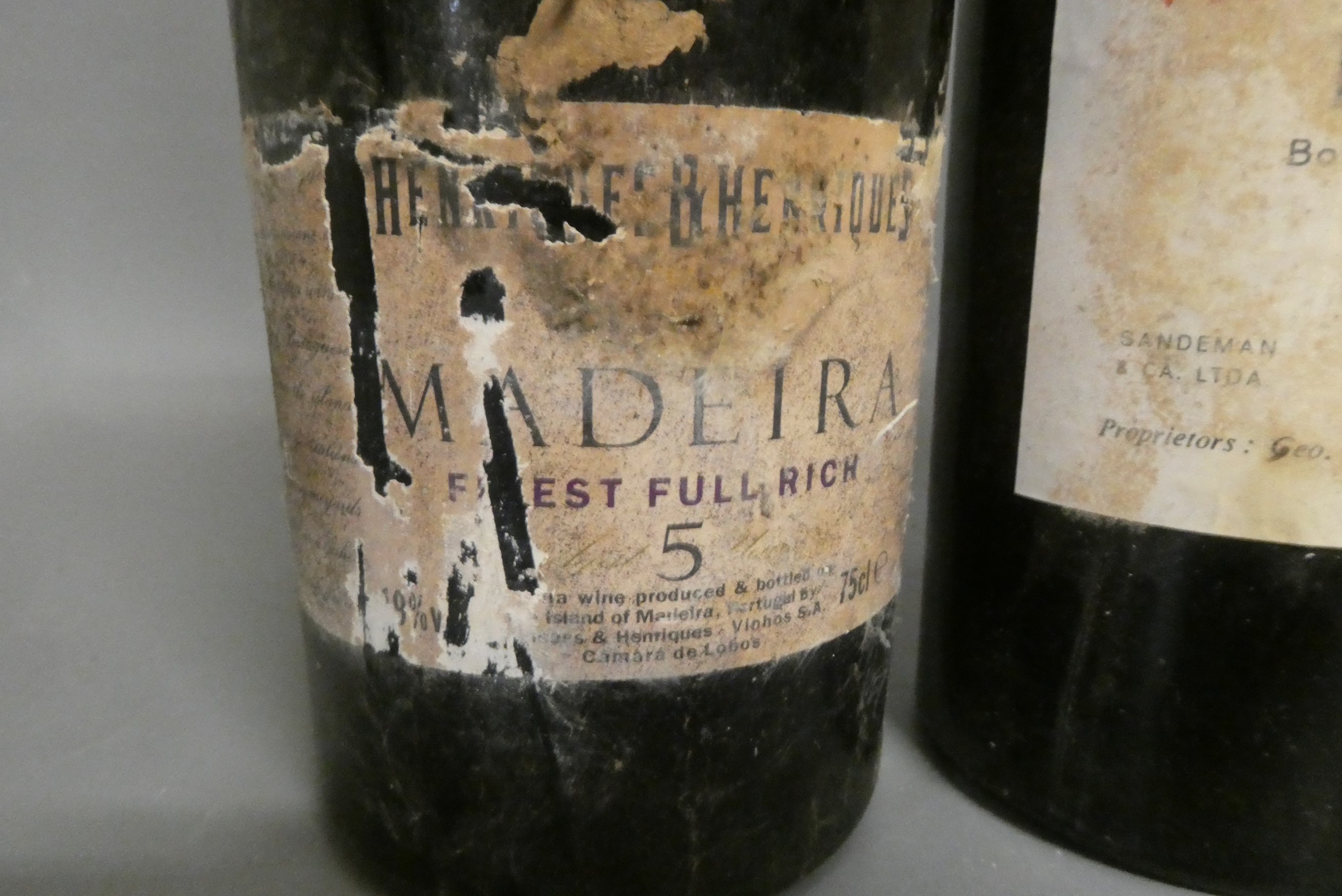 Two bottles of 1963 vintage port, comprising a Sandeman and a Graham's, together with a Henriques Image