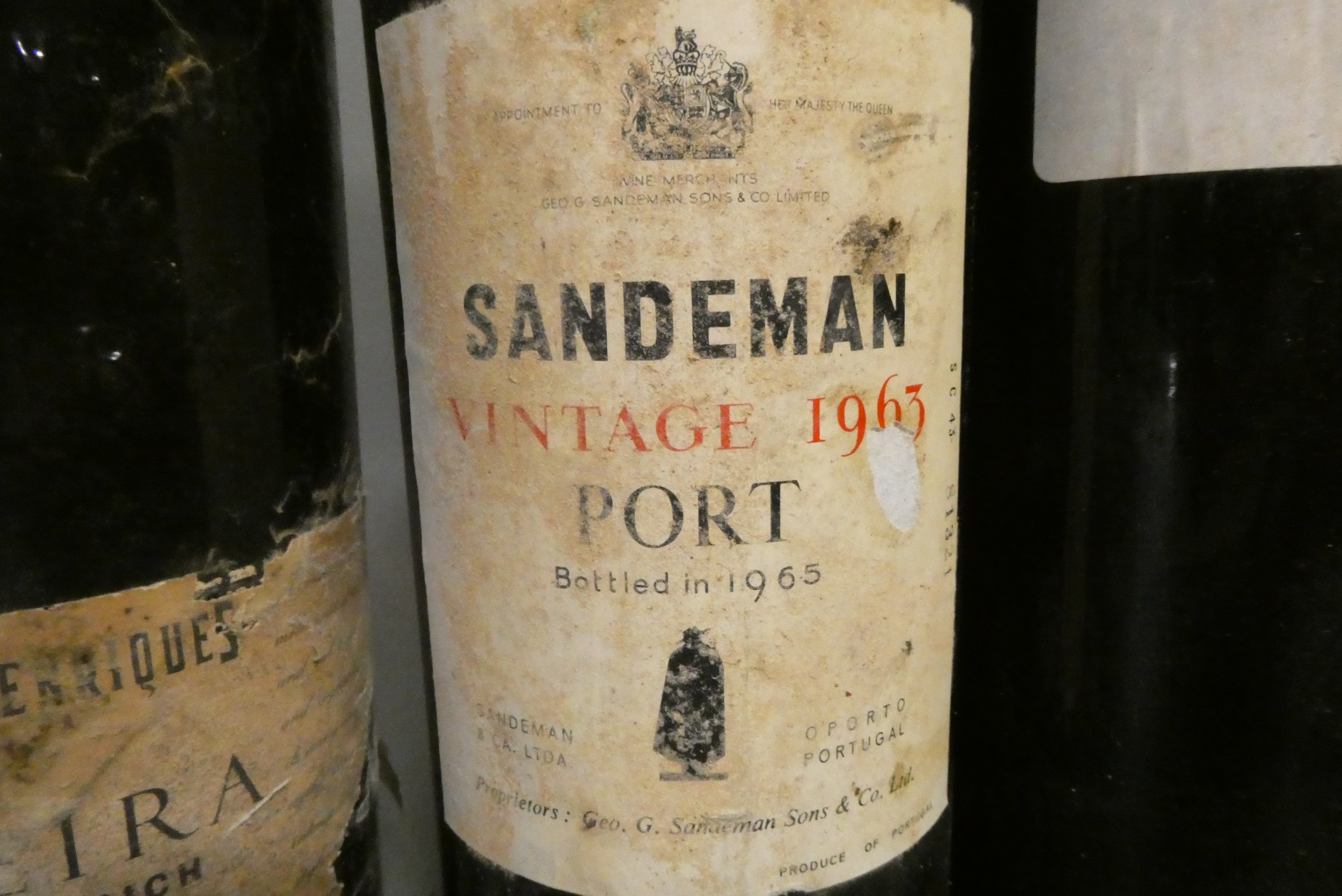 Two bottles of 1963 vintage port, comprising a Sandeman and a Graham's, together with a Henriques Image