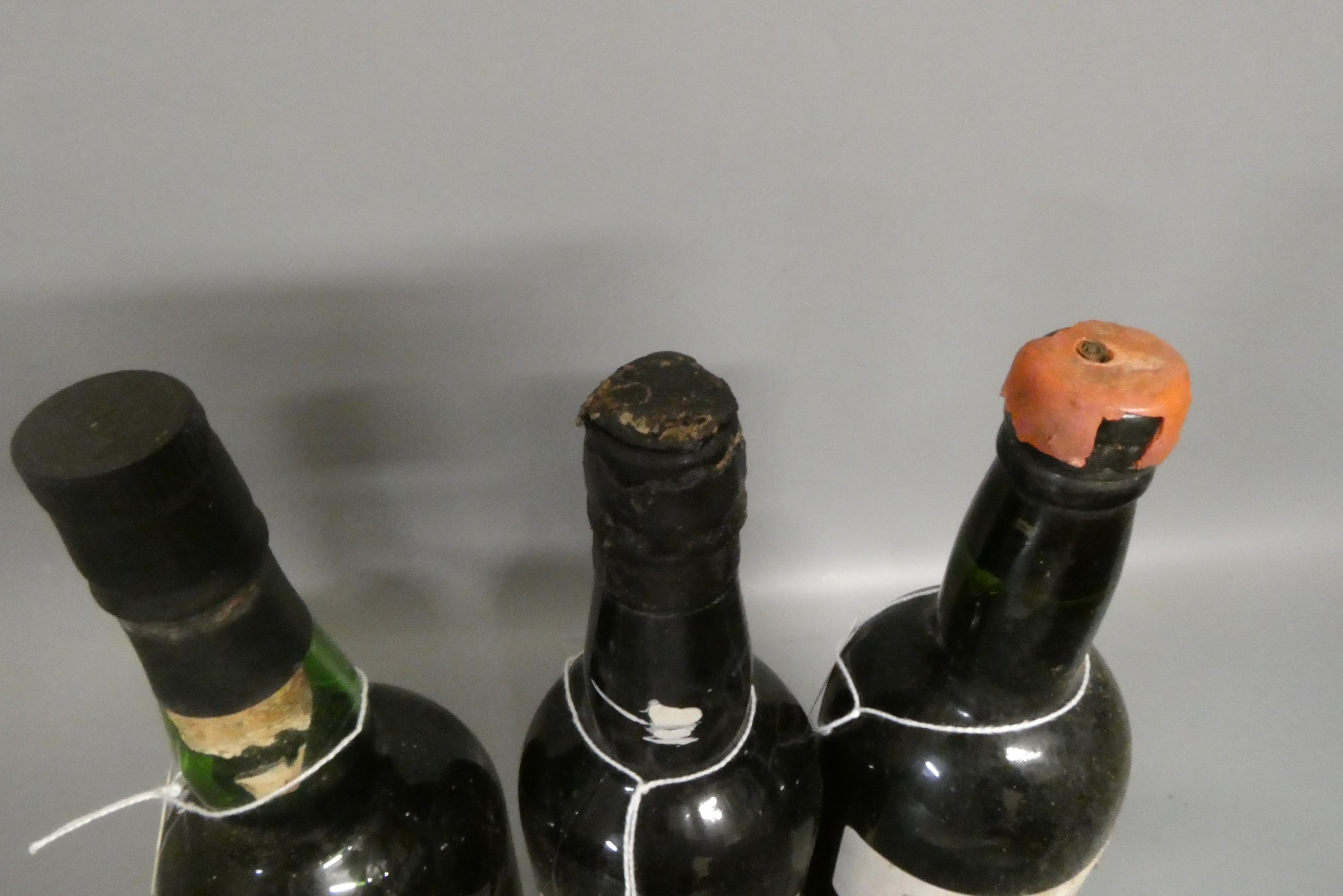 Two bottles of 1963 vintage port, comprising a Sandeman and a Graham's, together with a Henriques Image