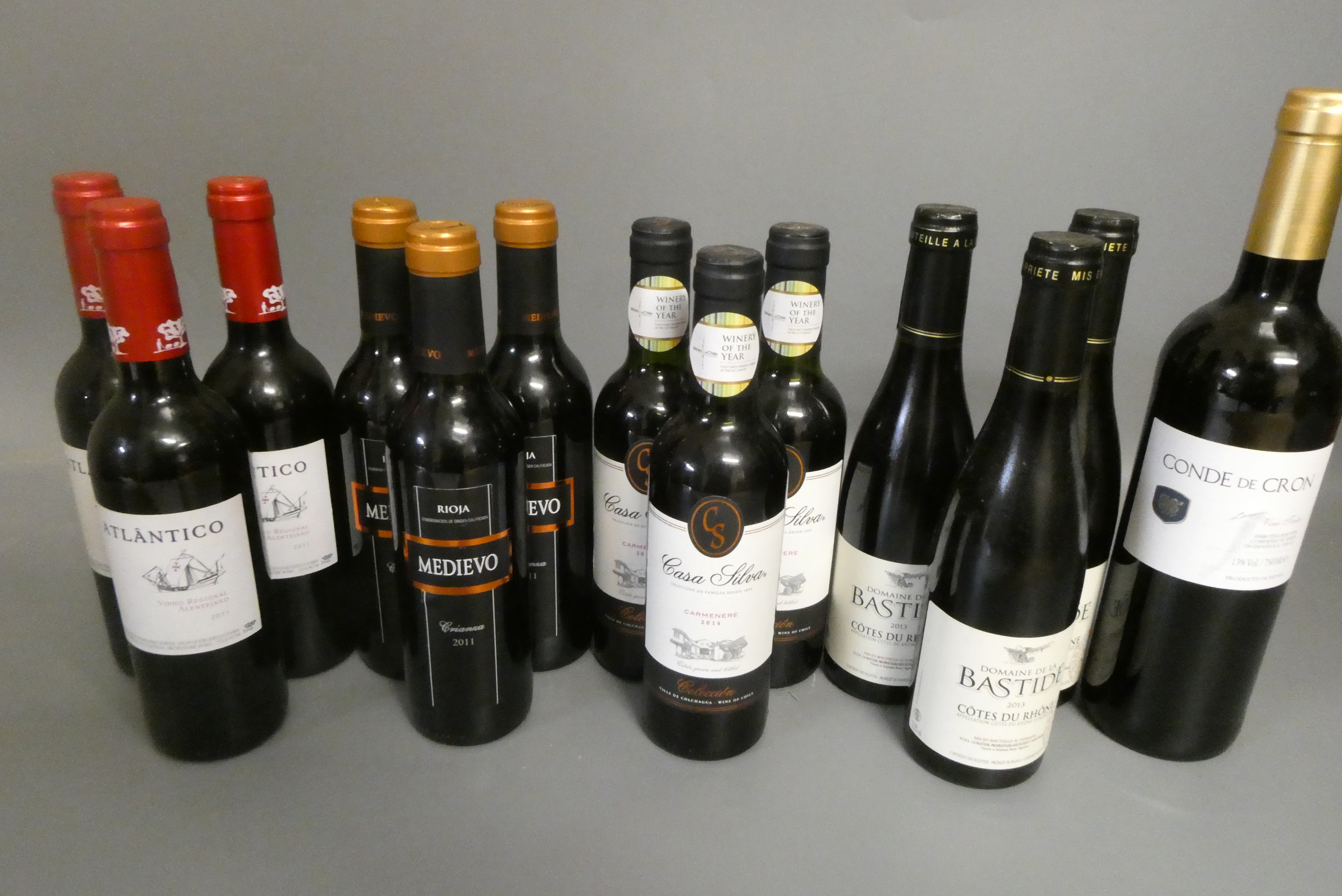 Twelve half and one full bottle of European red wine Image