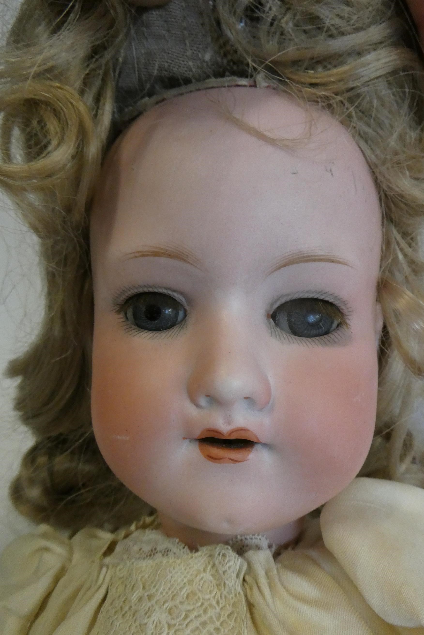An Armand Marseille bisque socket head doll, with blue glass sleeping eyes, open mouth, teeth, blond Image