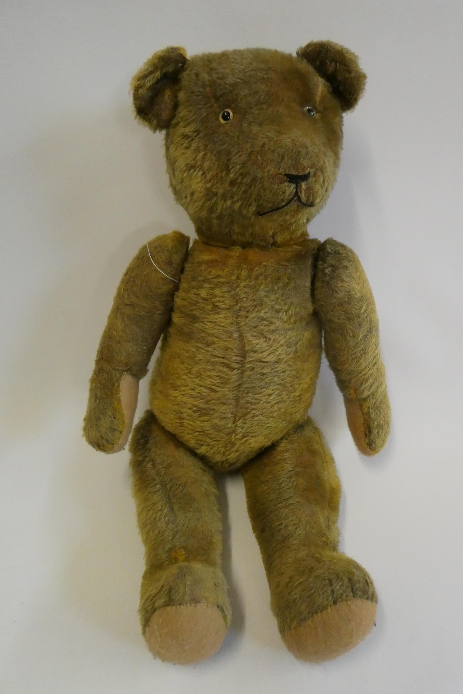 Pre-war jointed teddy bear, with clear glass eyes, orange plush sewn nose and felt pads, 26" long Image
