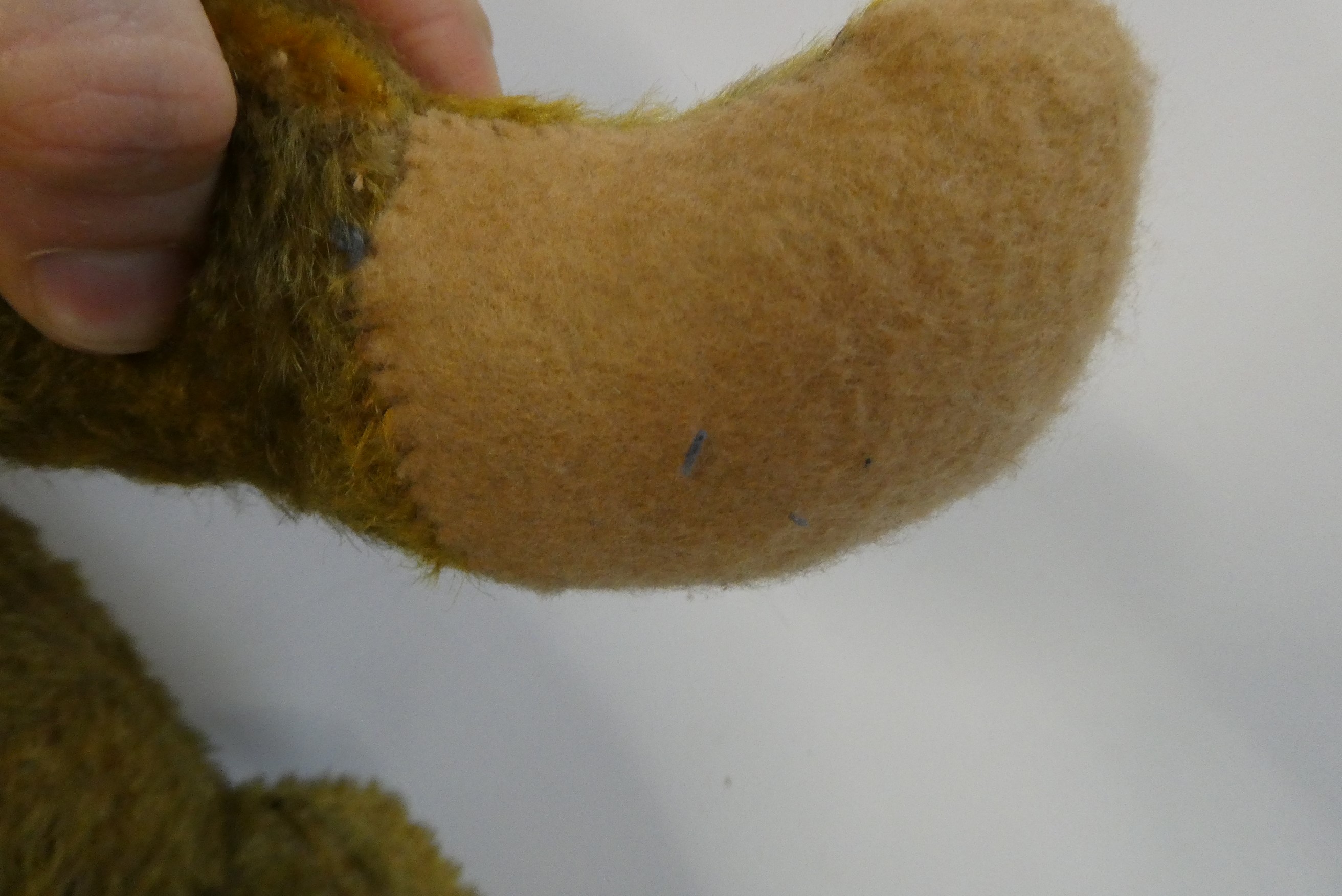 Pre-war jointed teddy bear, with clear glass eyes, orange plush sewn nose and felt pads, 26" long Image