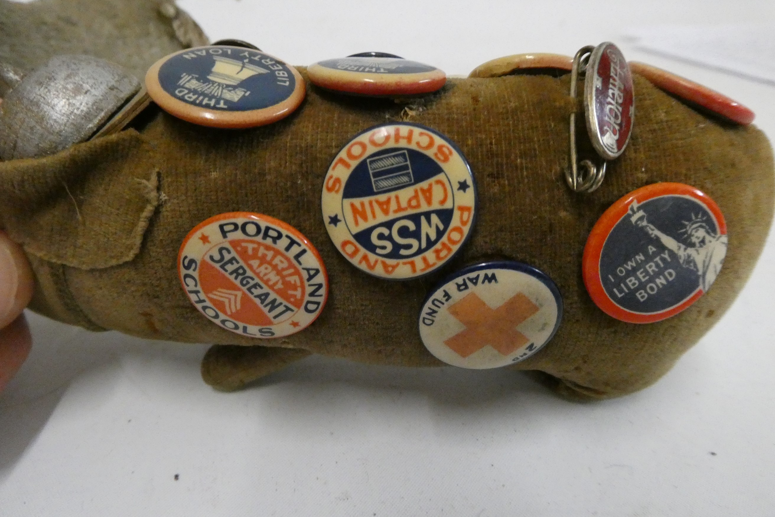 A 5 1/2" felt boar wearing a WWI style french helmet and covered in 16 badges including Portland Image