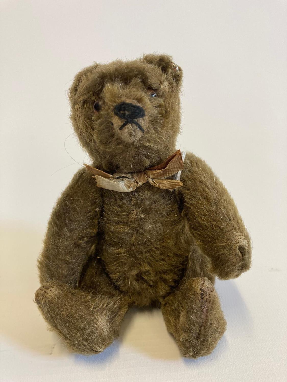 Small Steiff jointed bear, with glass eyes, brown plush, fabric bow and white metal ear button, 5 Image