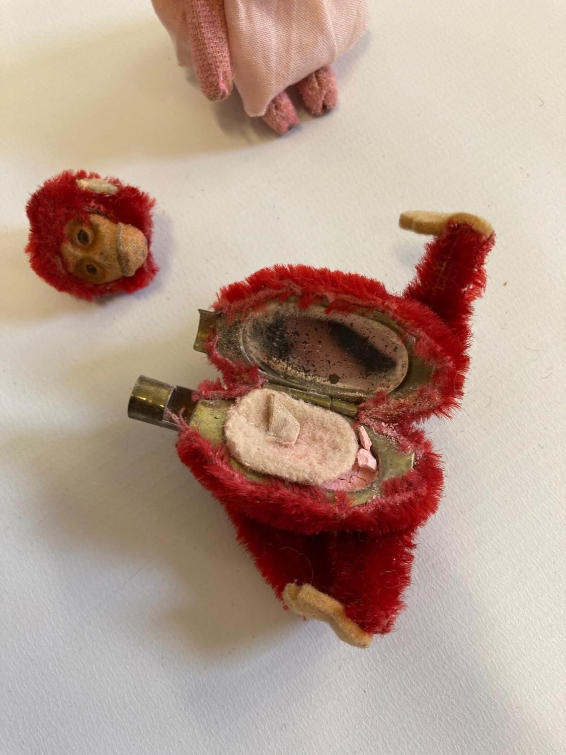 Two miniature Schuco animals, comprising a red monkey compact with internal mirror and puff, and a Image