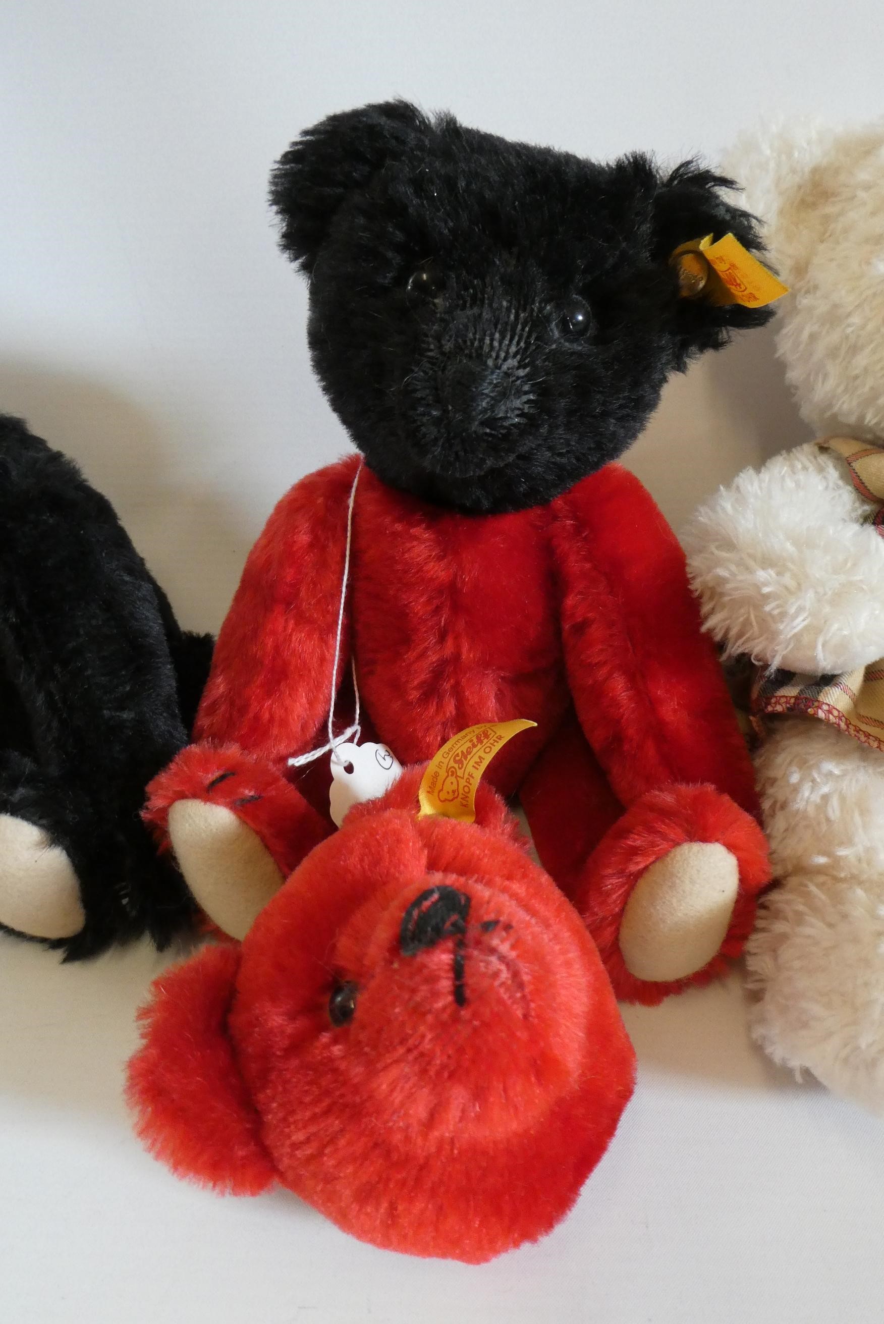 Three Steiff teddy bears including red and black bears with magnetic (interchangeable) joints, and a Image