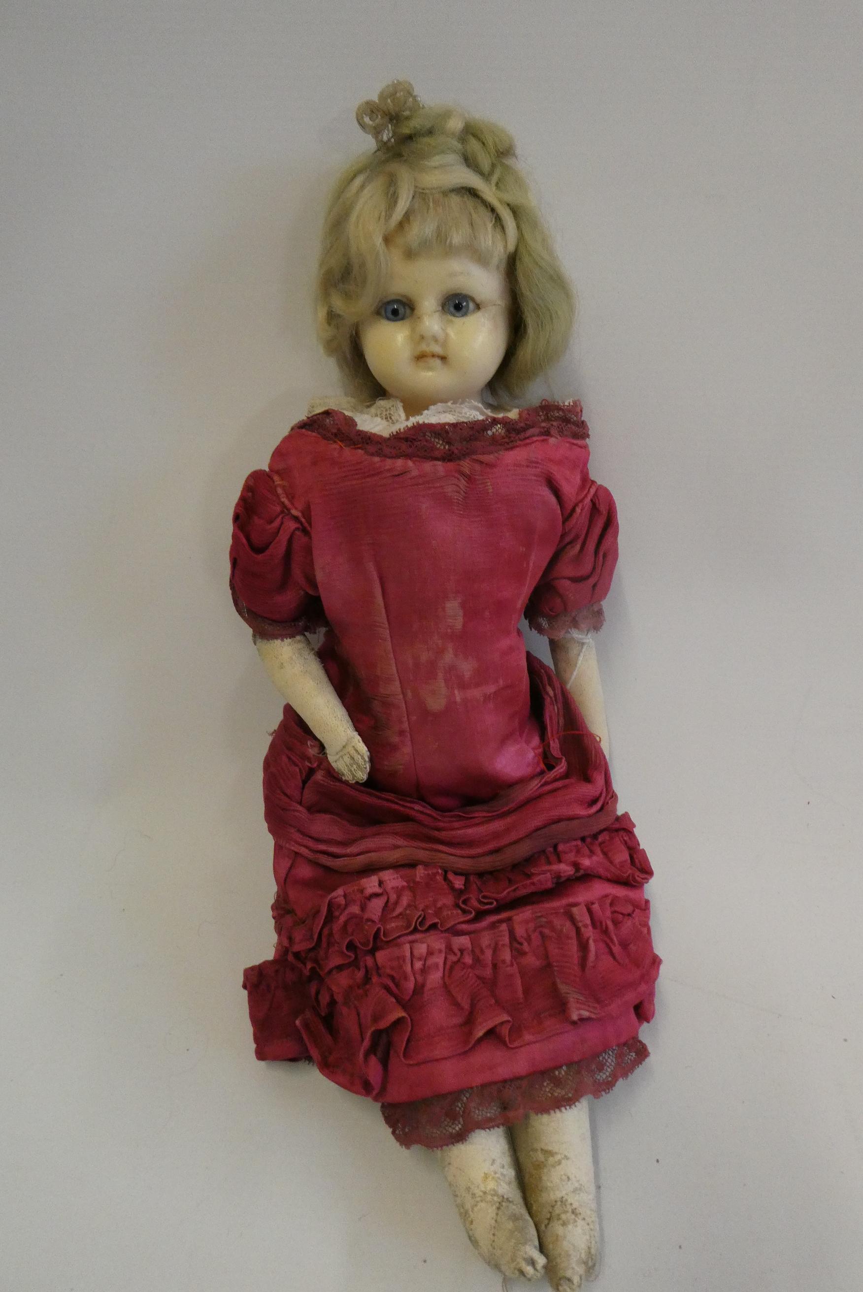 A Victorian wax shoulder head doll, with blue glass eyes, blond hair, closed mouth, kid body and Image