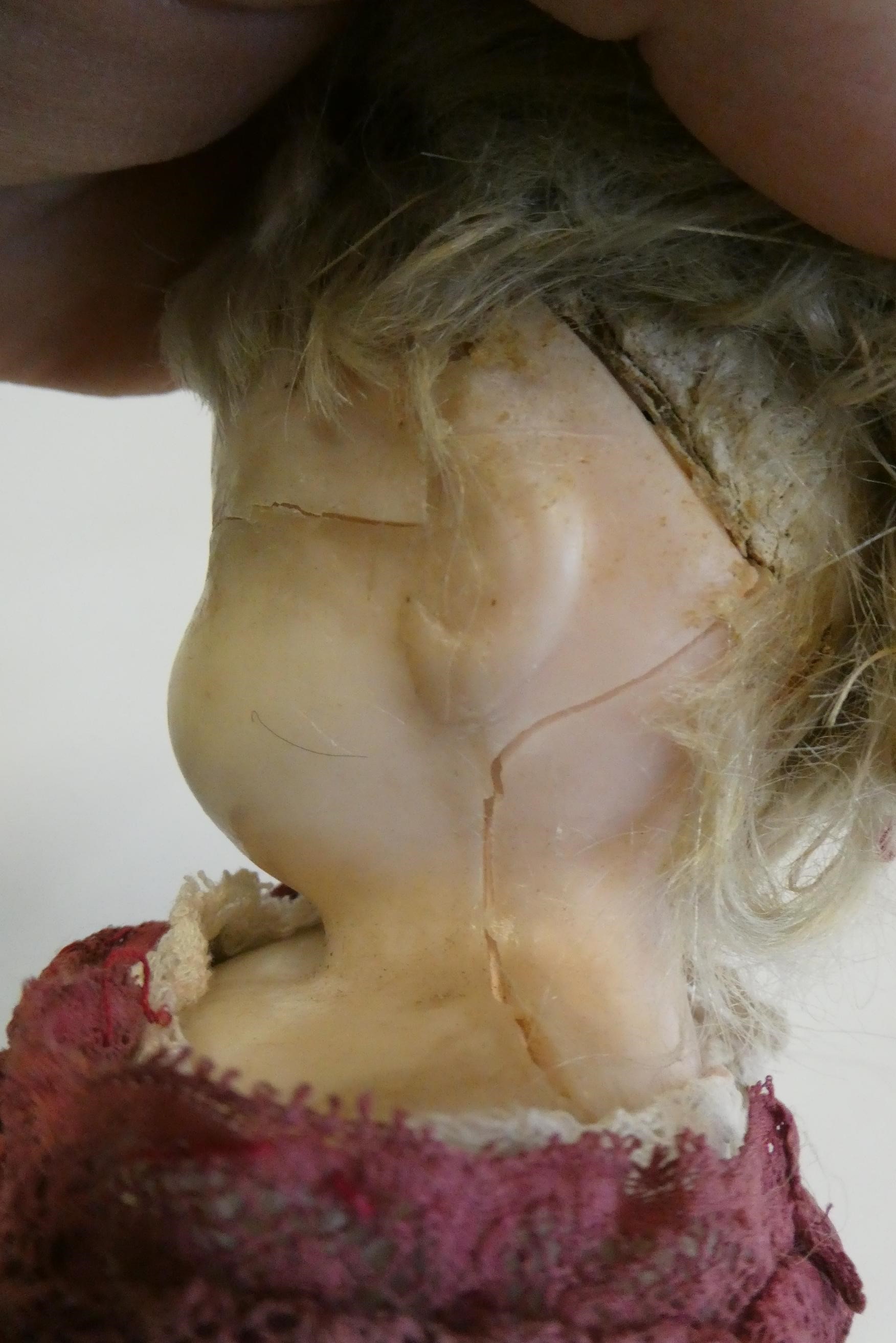 A Victorian wax shoulder head doll, with blue glass eyes, blond hair, closed mouth, kid body and Image