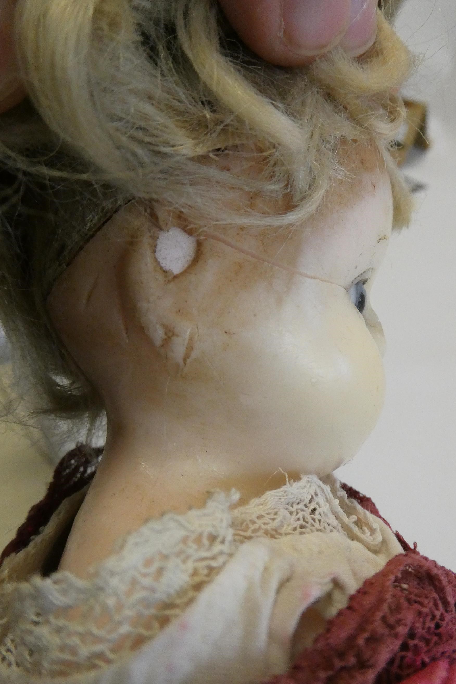 A Victorian wax shoulder head doll, with blue glass eyes, blond hair, closed mouth, kid body and Image