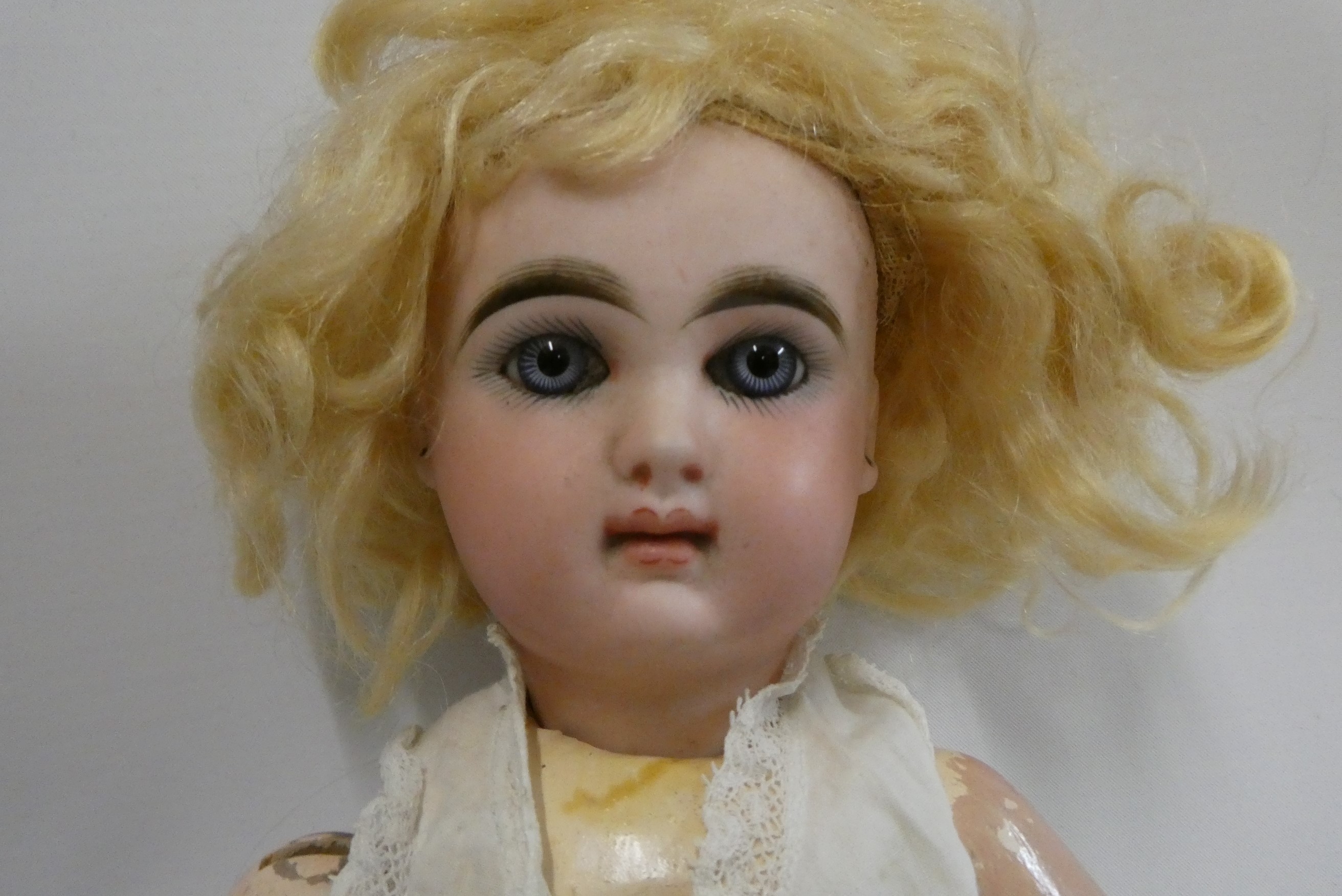A French bisque socket head girl doll, with blue glass fixed eyes, moulded closed mouth, pierced Image