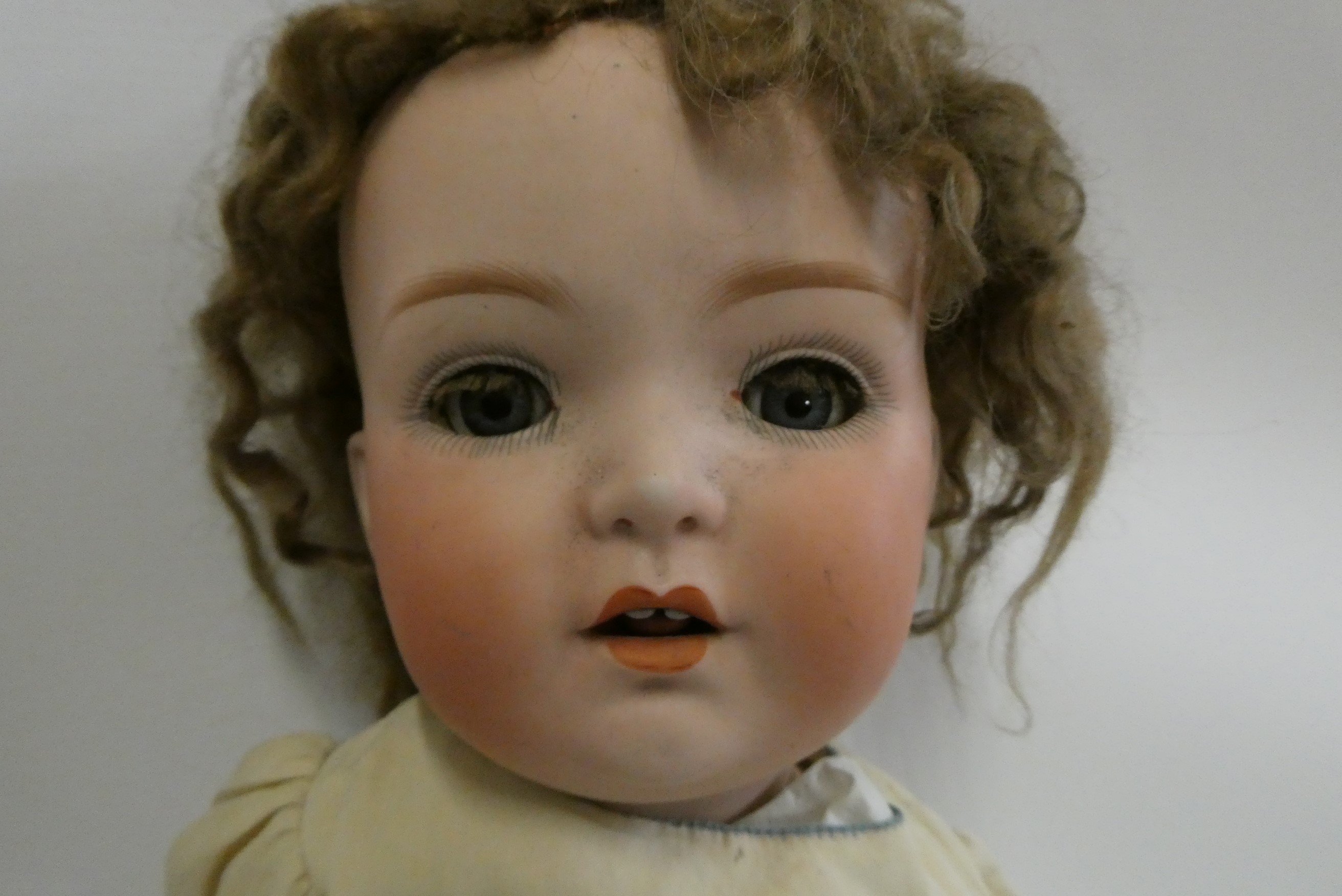 A Heubach bisque socket head doll, with blue glass sleeping eyes, open mouth, teeth, tongue, bent Image