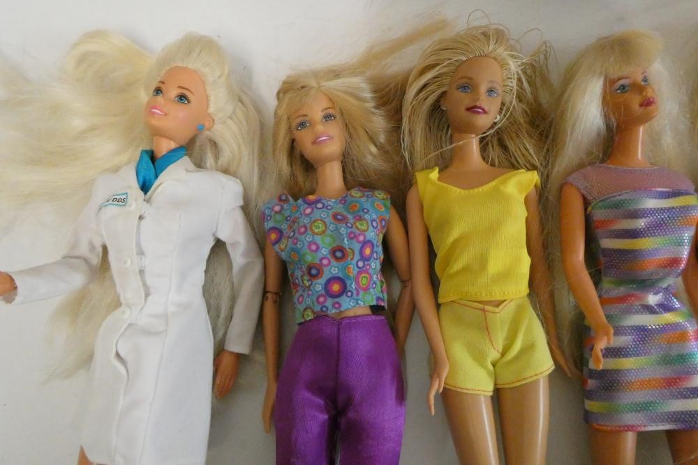 Twelve Barbie dolls, comprising ten Barbies, two younger sisters and a Barbie camera Image