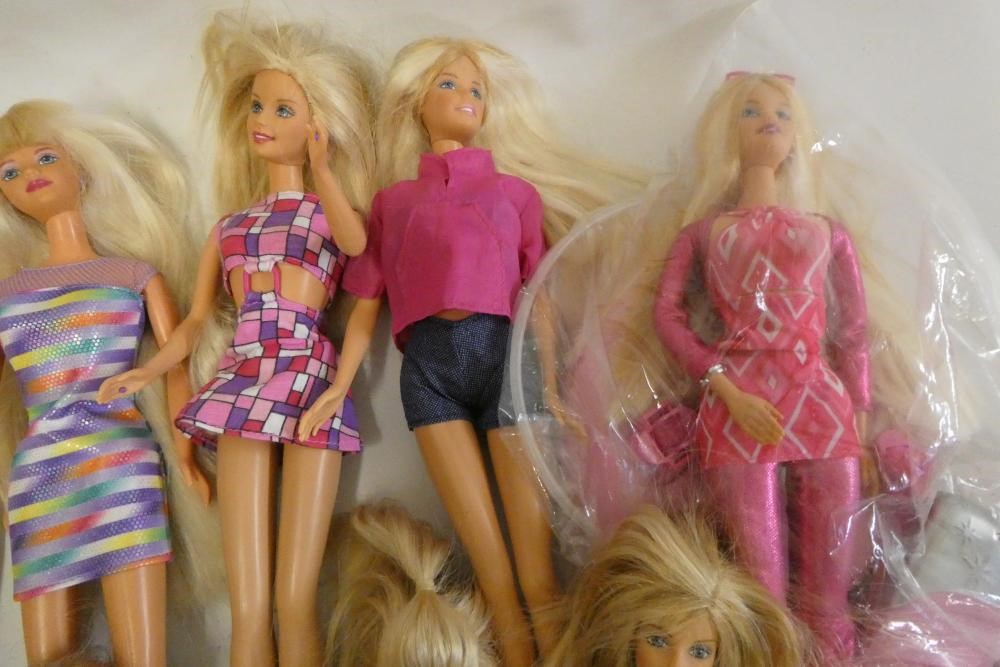 Twelve Barbie dolls, comprising ten Barbies, two younger sisters and a Barbie camera Image