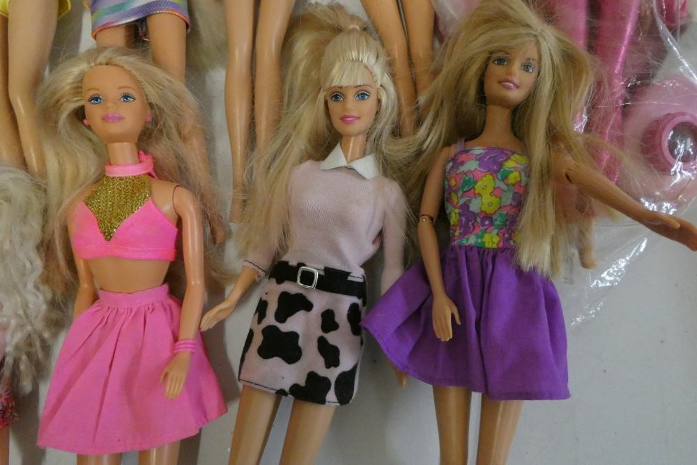 Twelve Barbie dolls, comprising ten Barbies, two younger sisters and a Barbie camera Image