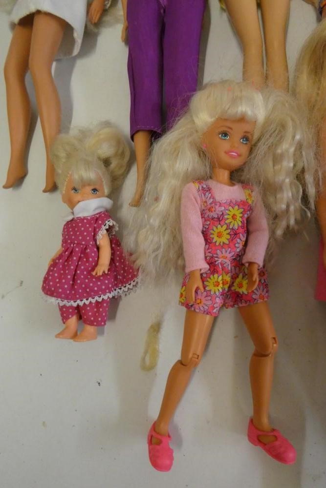 Twelve Barbie dolls, comprising ten Barbies, two younger sisters and a Barbie camera Image