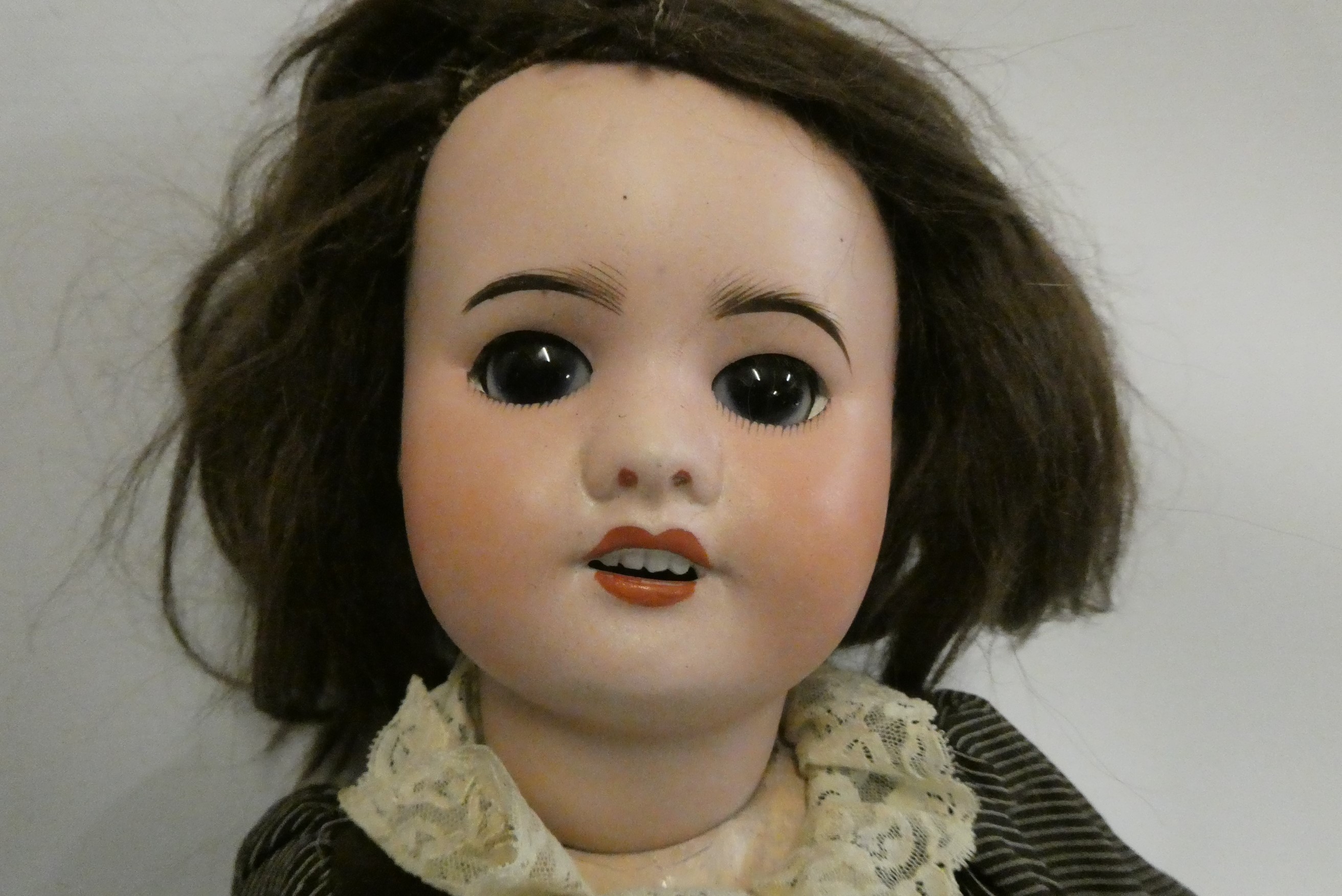 An SFBJ bisque socket head doll, with brown glass sleeping eyes, open mouth, teeth, brown wig, wood Image