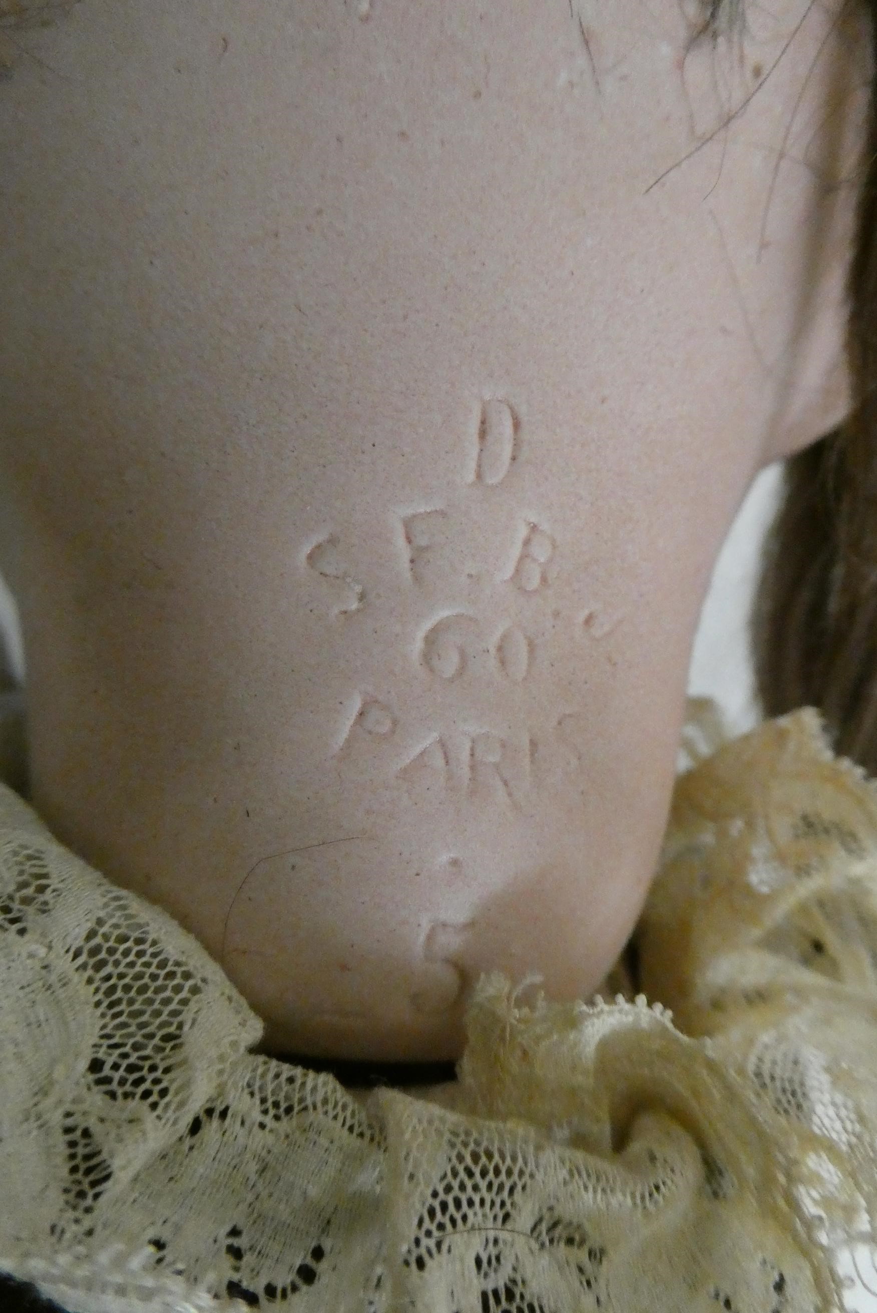 An SFBJ bisque socket head doll, with brown glass sleeping eyes, open mouth, teeth, brown wig, wood Image