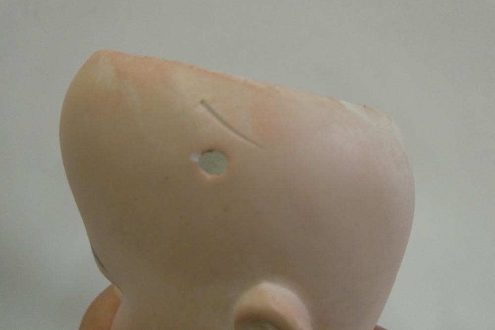 An Arthur Schoenau bisque socket head doll, with blue glass fixed eyes, open mouth, teeth, wood and Image