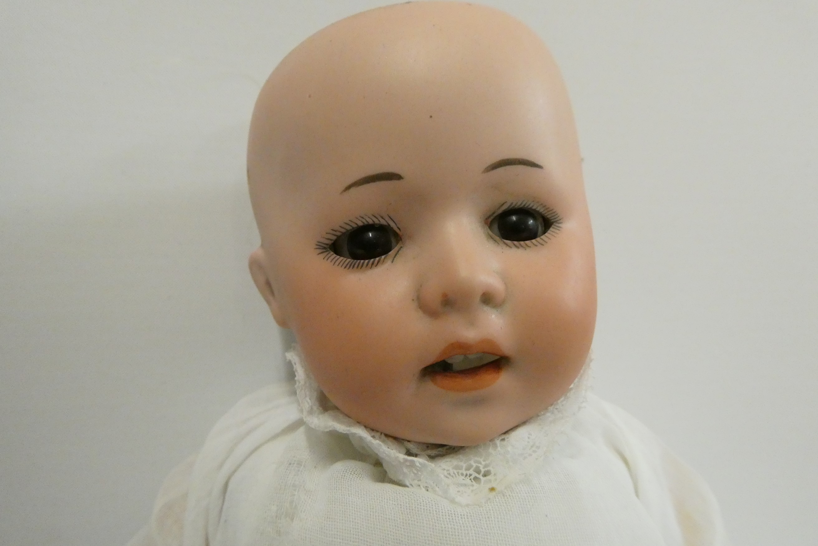 A German bisque socket head doll, with brown glass sleeping eyes, oepn mouth, teeth, bent limb Image