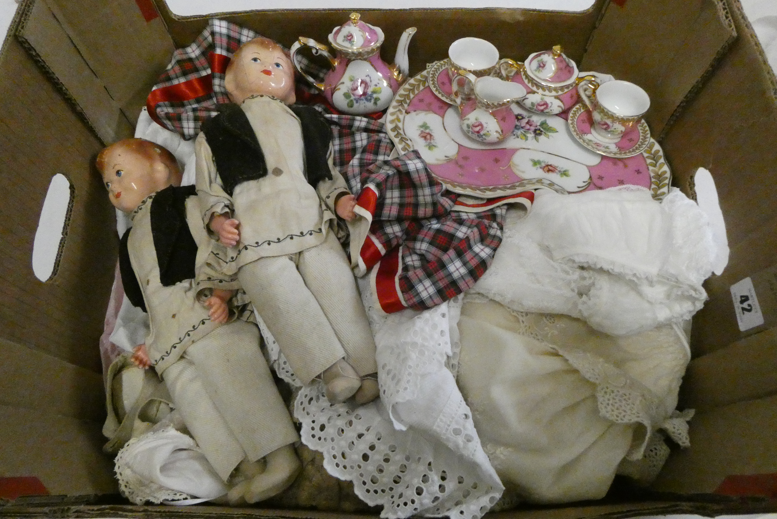 A box of dolls, clothing and accessories, including a pair of vintage composition head boys, a Image