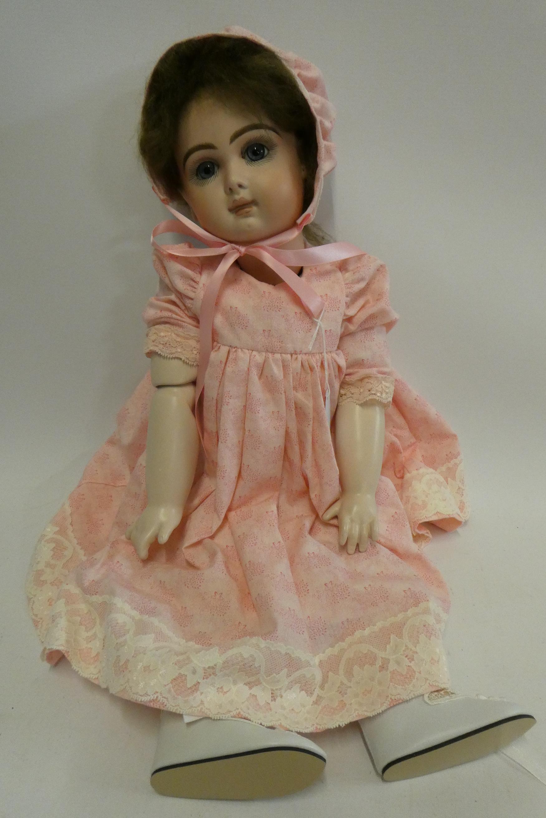 A reproduction "Jumeau" bisque socket head doll, with blue glass fixed eyes, closed mouth, pierced Image