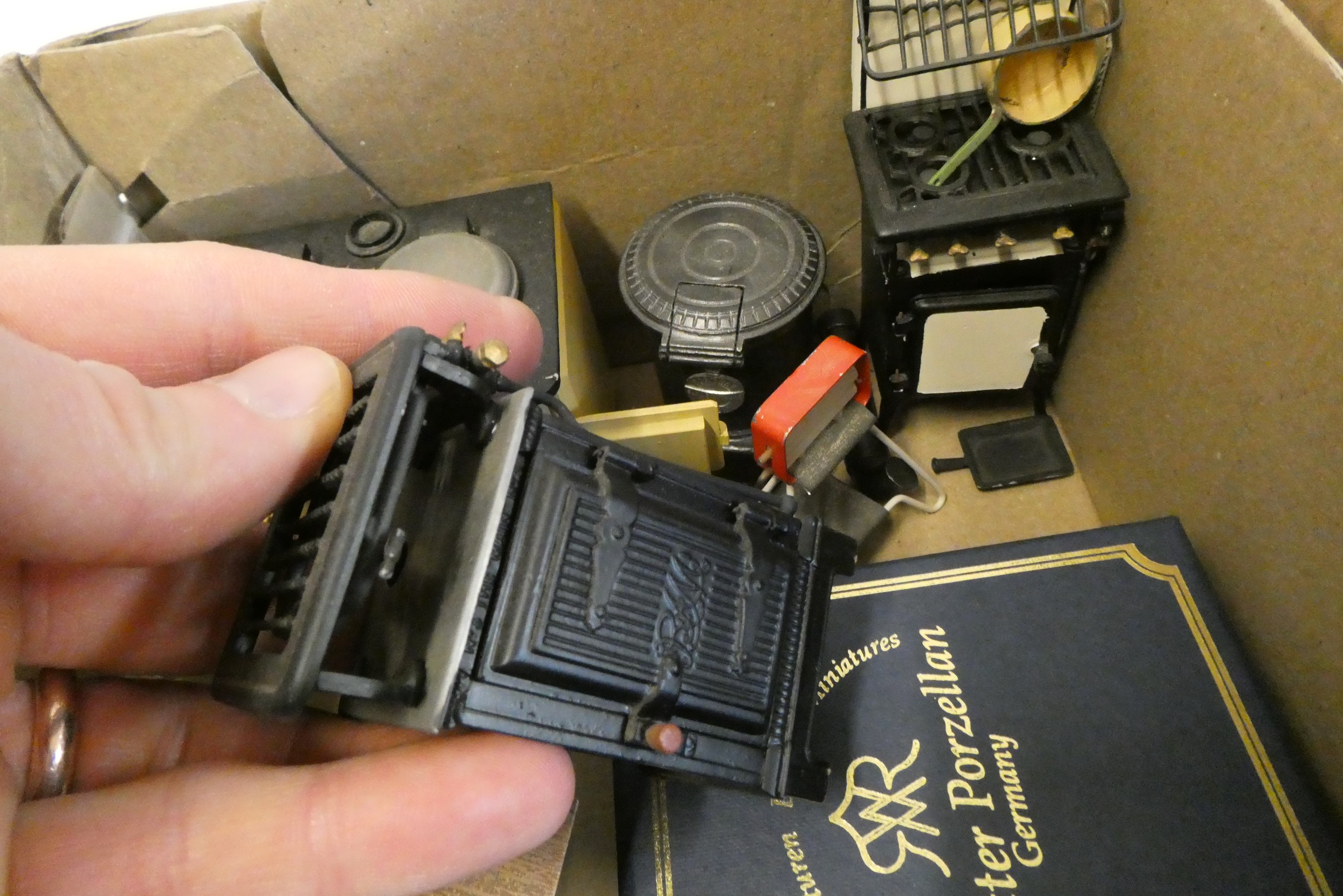 A collection of doll's house kitchen and other accessories, including metal items, ovens, food and a Image