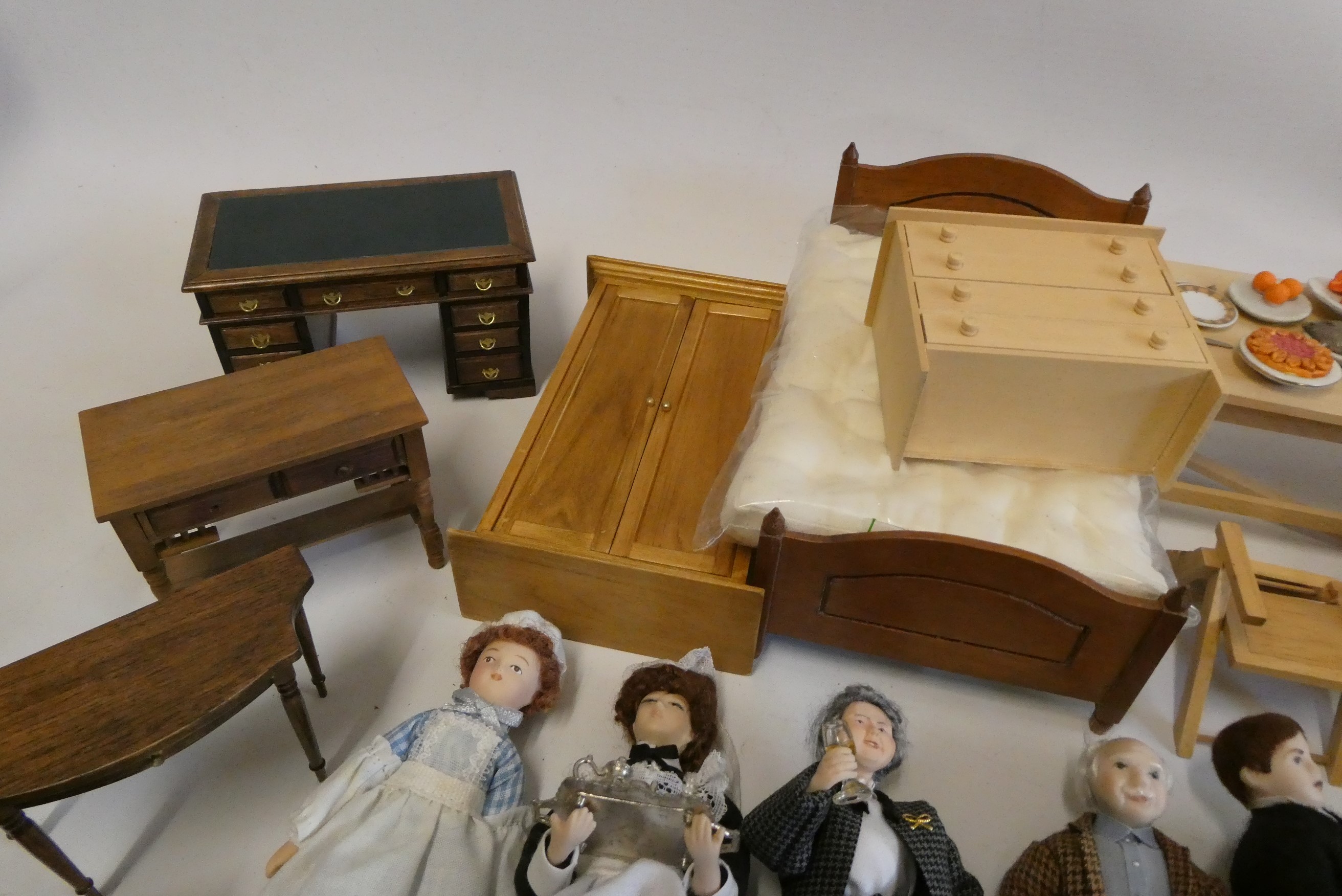 A collection of doll's house furniture and dolls, including wardrobes, dining tables chairs, chests Image