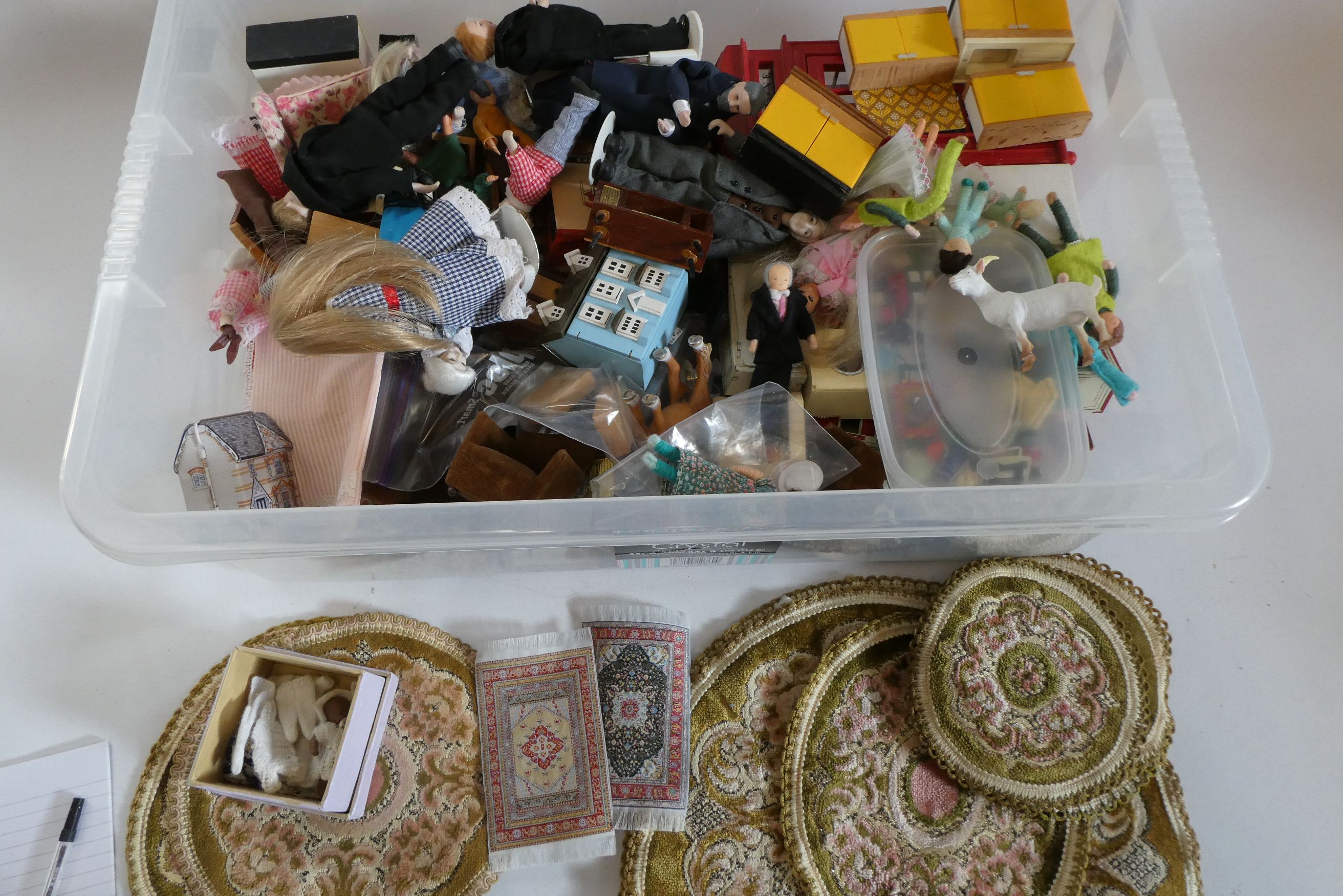 A box of dolls house furniture, dolls and accessories, including a large model telephone box, rugs Image