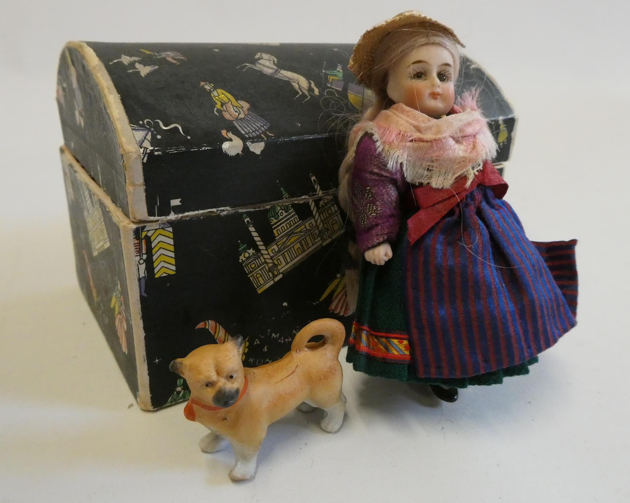 An all bisque dolls house doll, with brown glass fixed eyes, blond wig, straight legs, moulded shoes Image